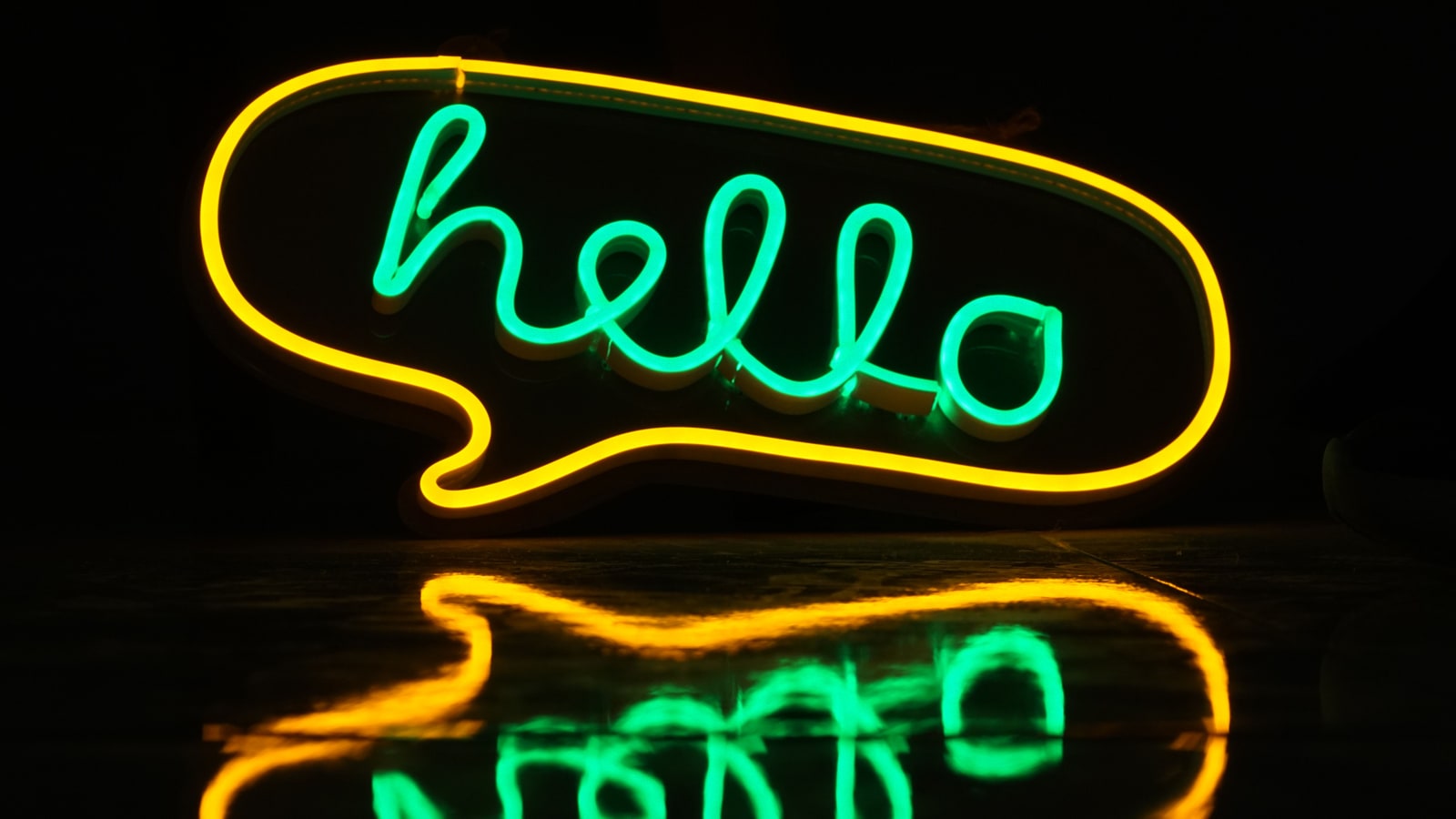 Leuchtreklame in Form einer Sprechblase mit dem Schriftzug „hello"