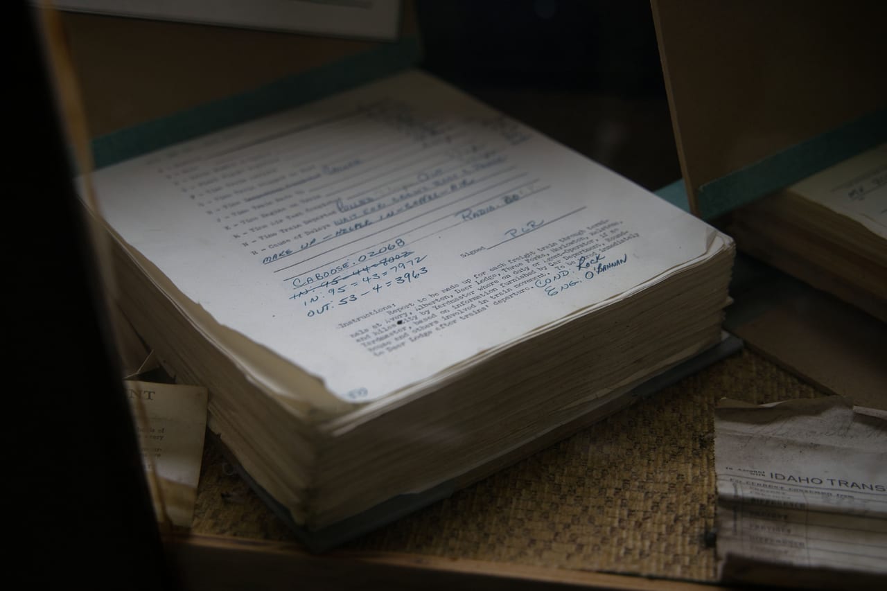 Aufgeschlagenes, dickes Belegbuch mit handschriftlich ausgefüllten Formularen im Halbdunkel