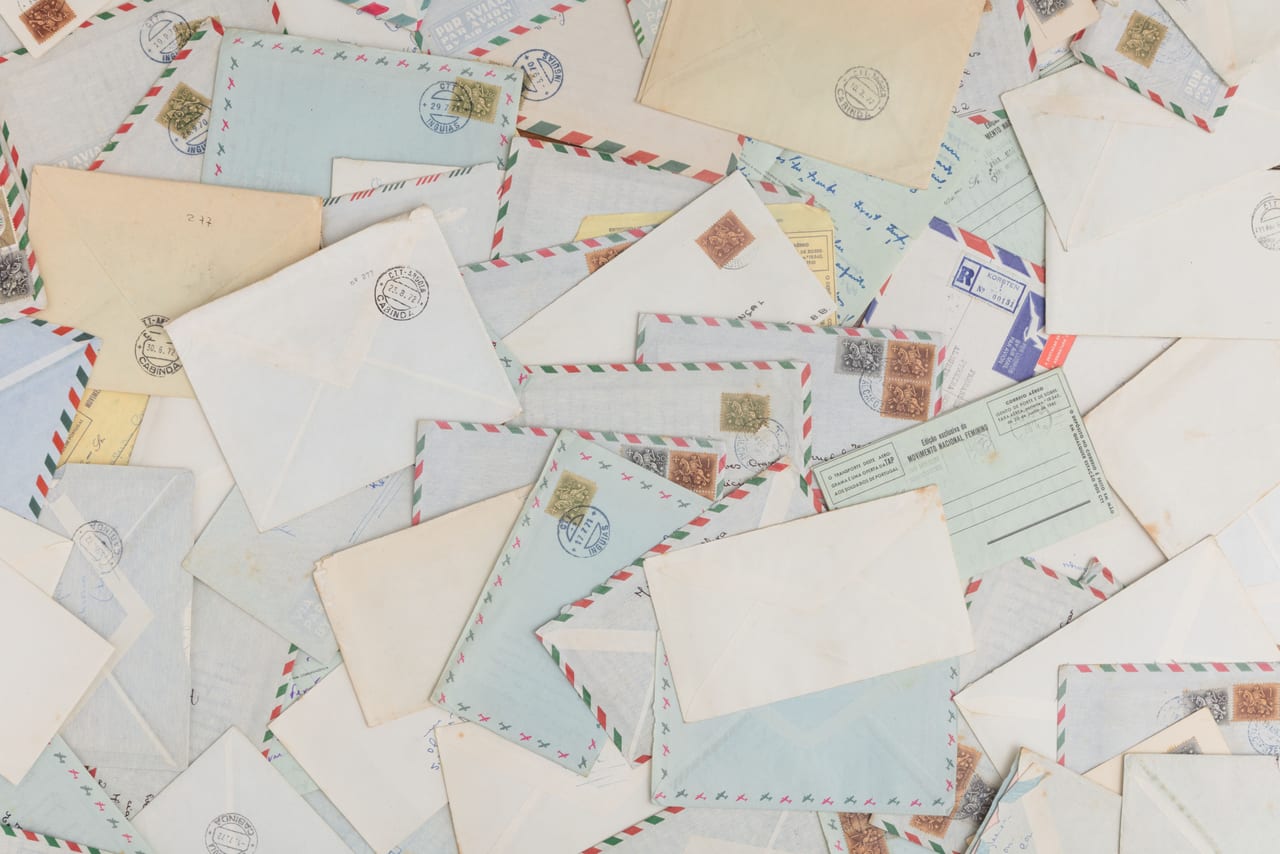Verstreute Luftpostumschläge mit Briefmarken und rot-blau gestreiftem Rand