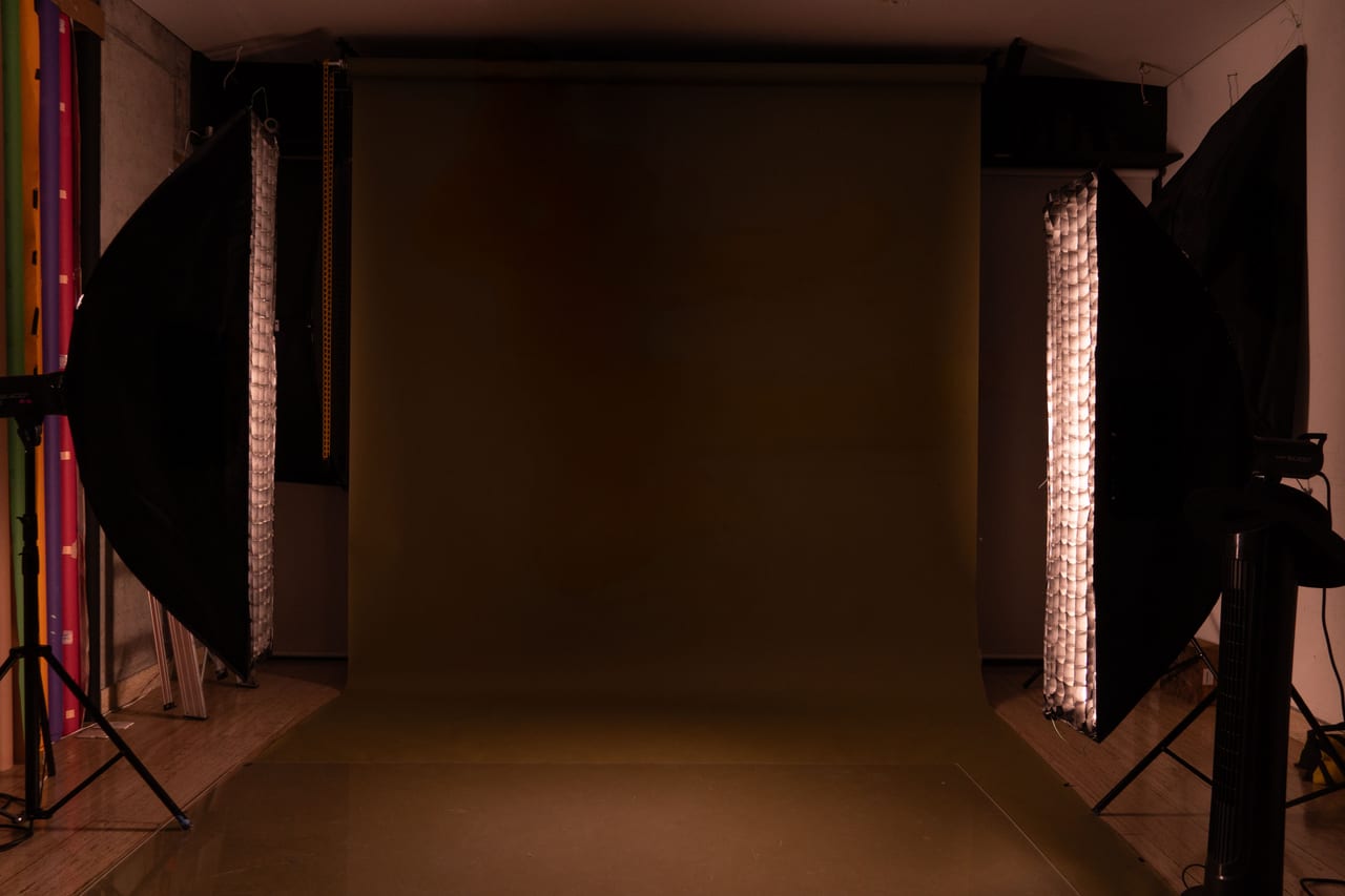Leeres Fotostudio mit je einer Softbox links und rechts vor mokkafarbenem Hintergrundkarton