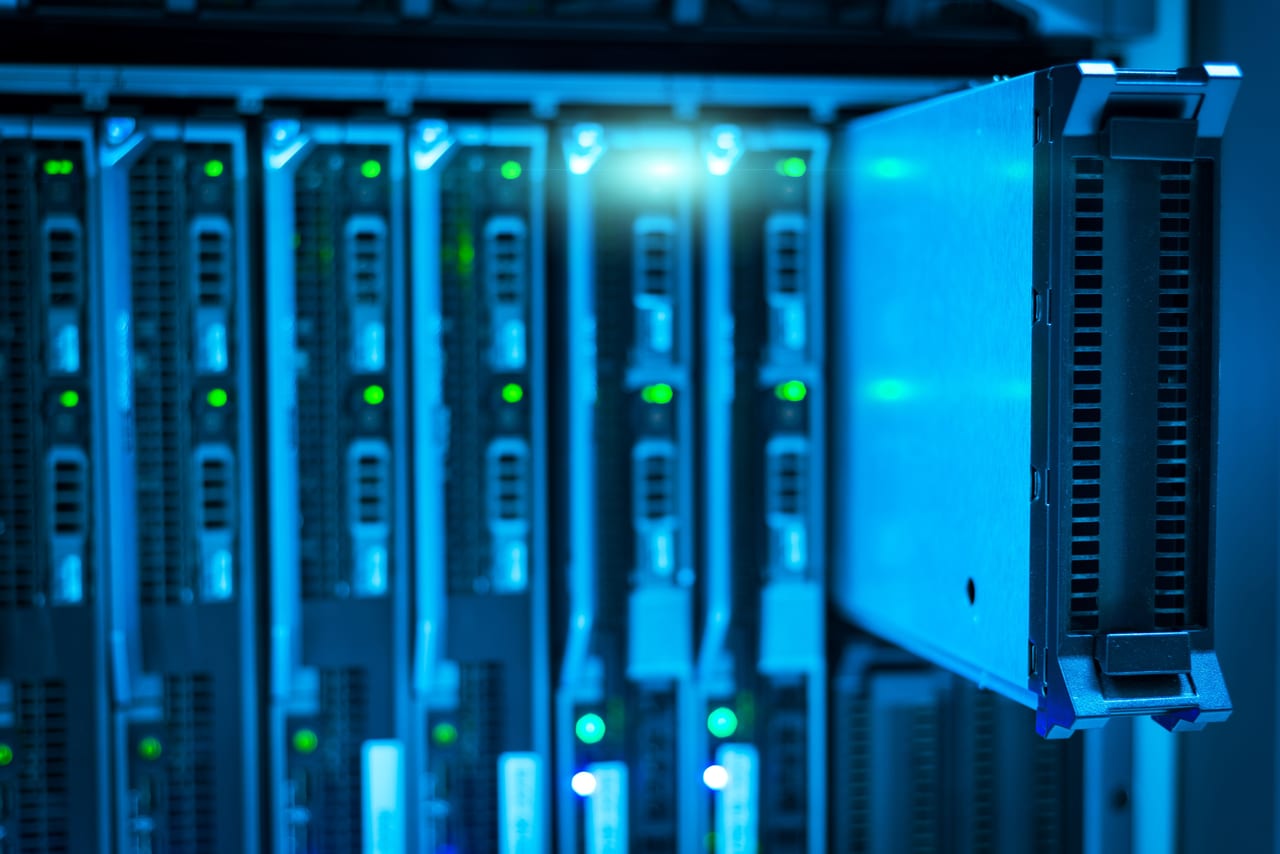 Blau beleuchtete Serverschränke in einem Rechenzentrum, ein Einschub steht offen