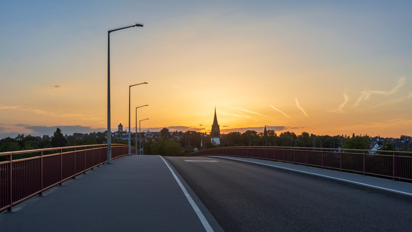 Brücke in Heilbronn-Böckingen nach Sonnenuntergang, im Hintergrund ein Kirchturm